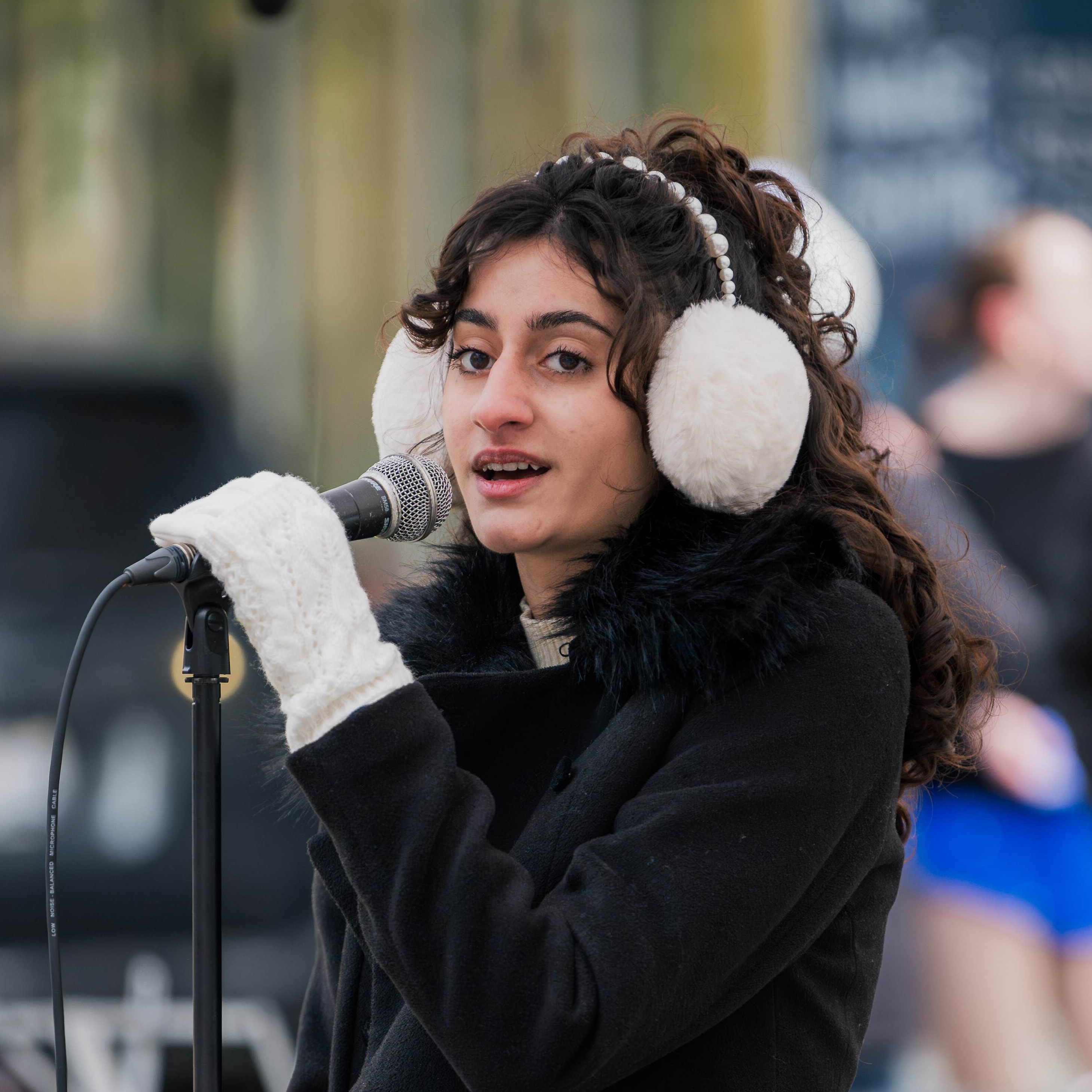 Anahita in front of microphone singing.